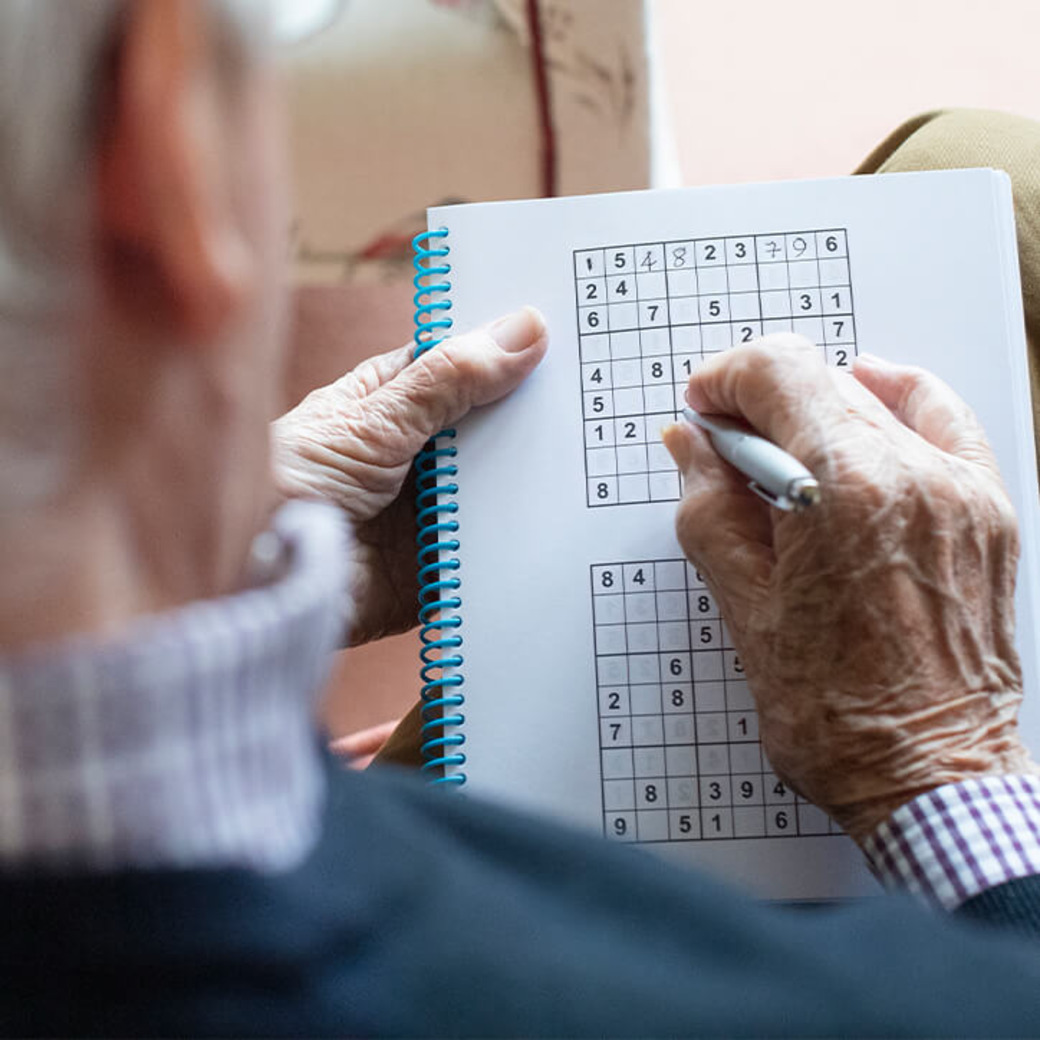 Alter Mann spielt Sudoku