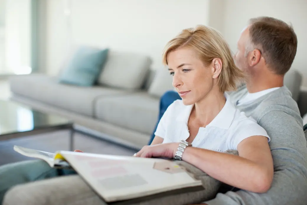 Жена, която седи с мъжа си на диван и чете
