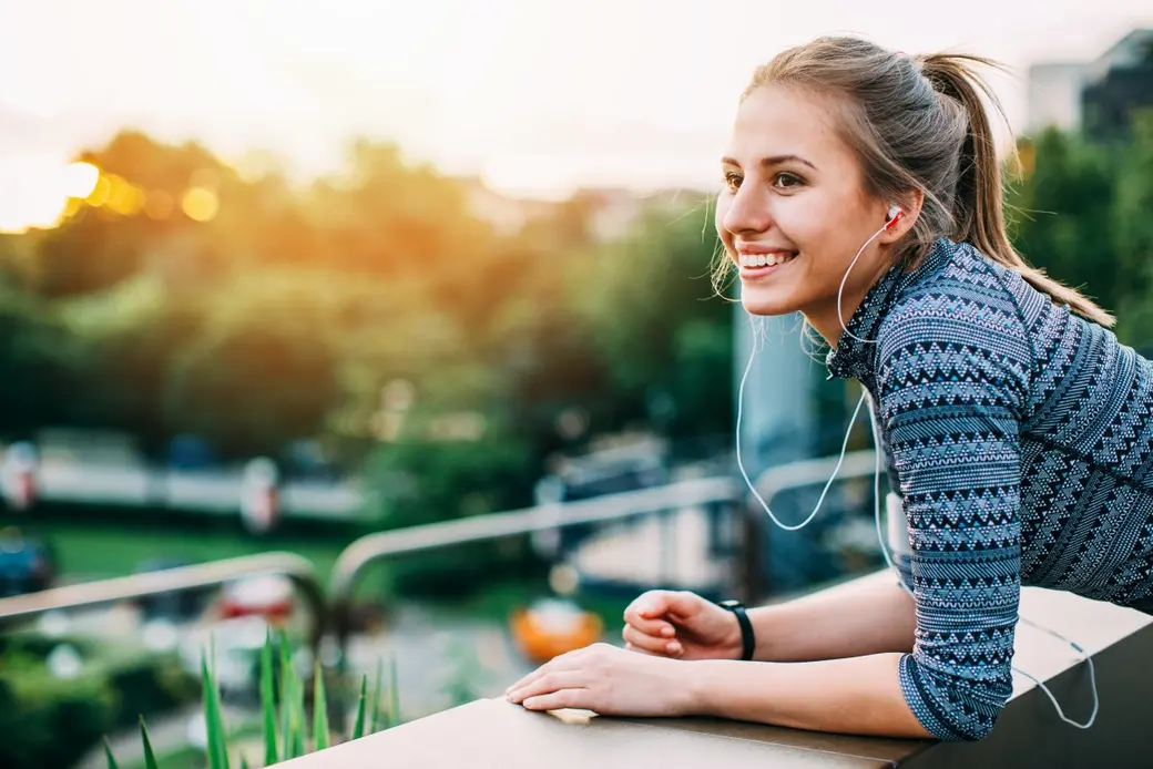 Жена със спортен екип, която се наслаждава на гледката в парк